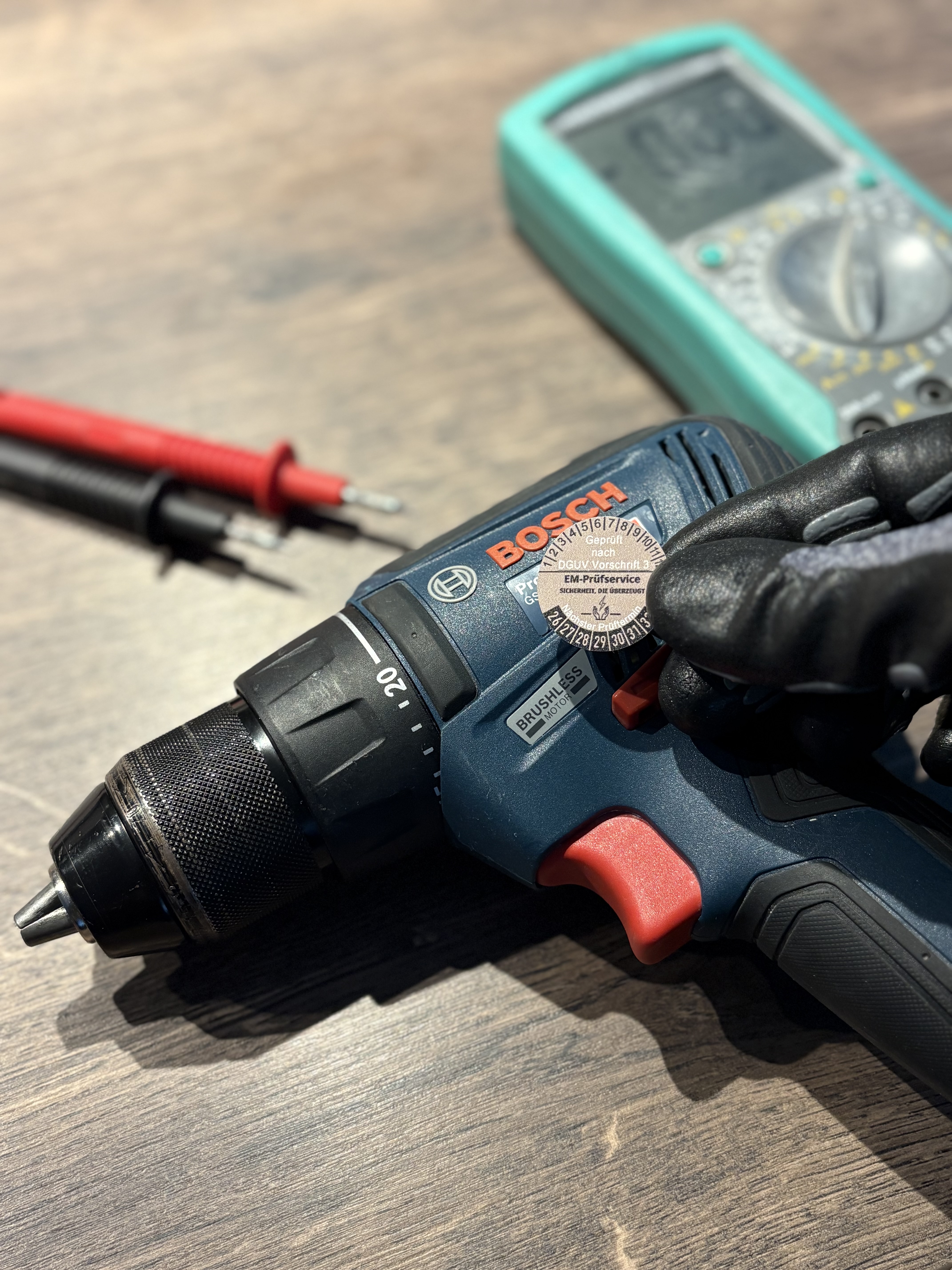 Elektrofachkraft prüft ortsveränderliches Betriebsmittel mit Messgerät